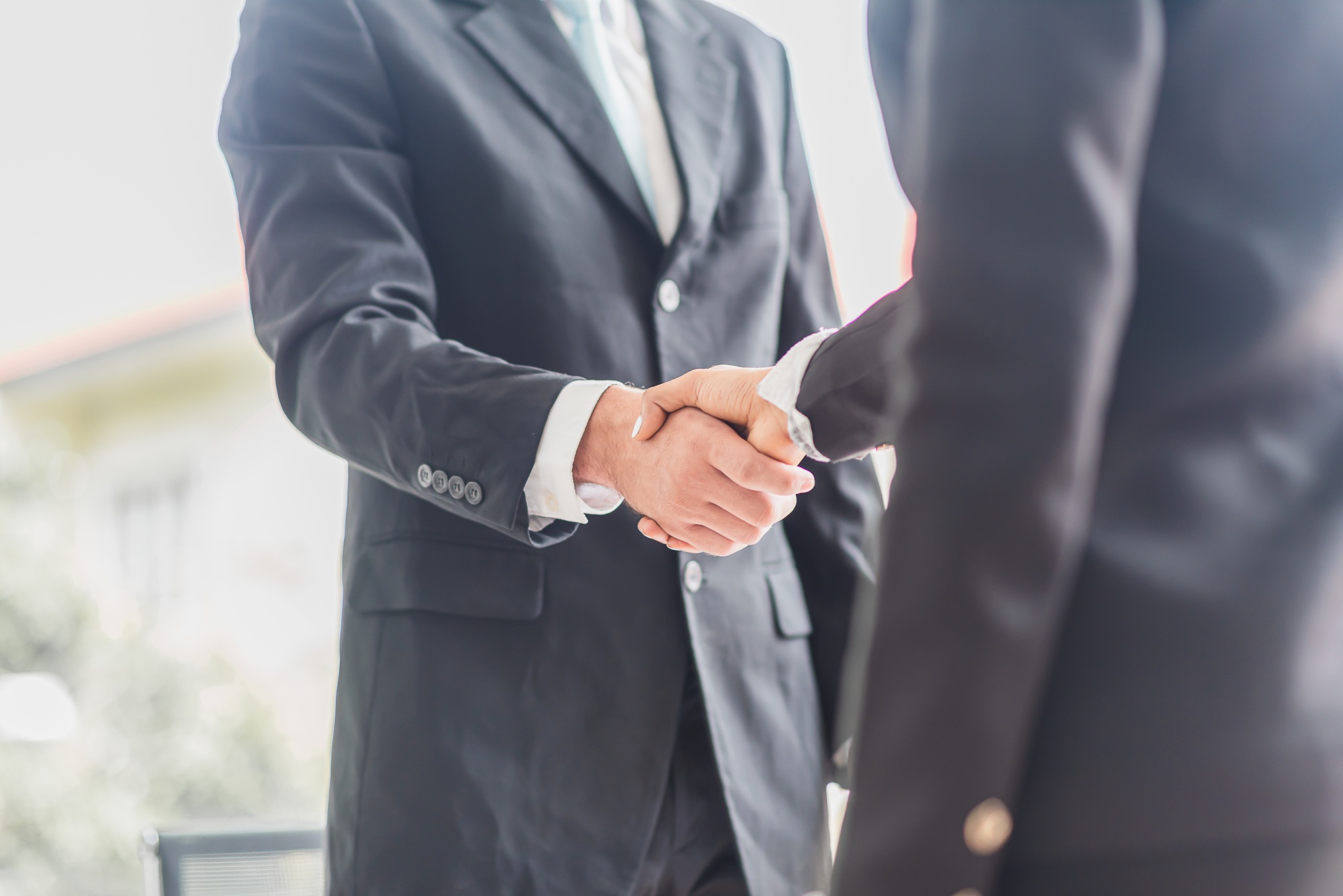Business man shake hands with business women agreeing on partnerships or introducing themselves